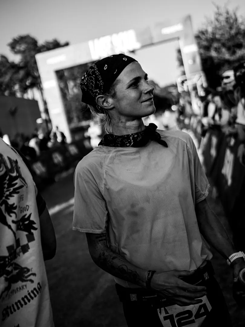 A smiling runner under the start arch, in black and white.