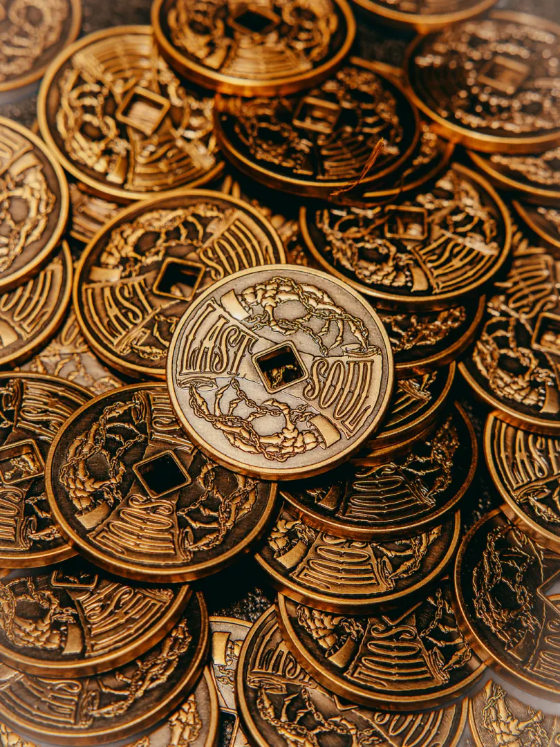 A pile of old coins with one large coin on top.