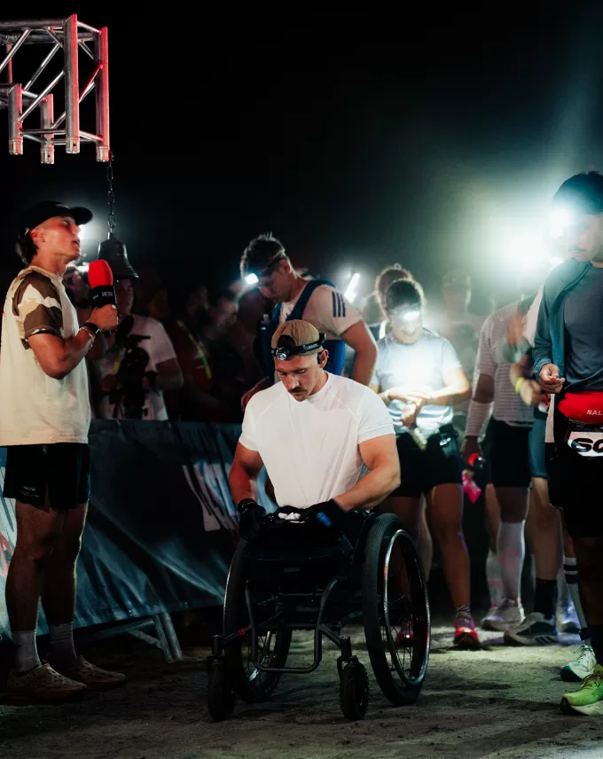 Runners in head torches gathered at the start in the dark, a wheelchair athlete at the front